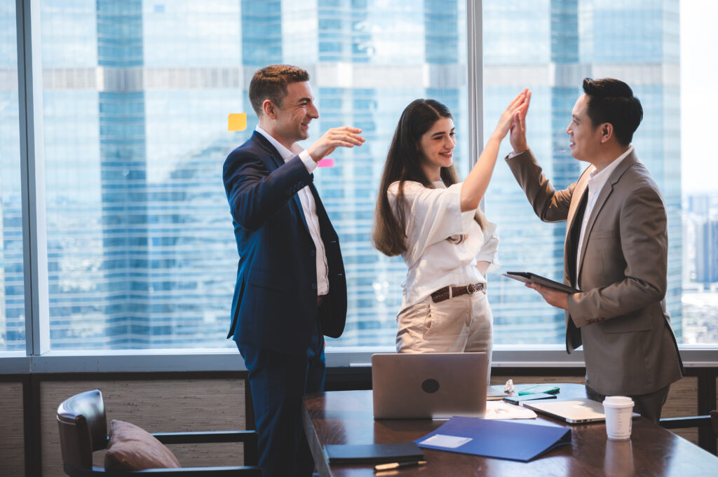 2020 search partners, Business professionals high-fiving after a successful meeting