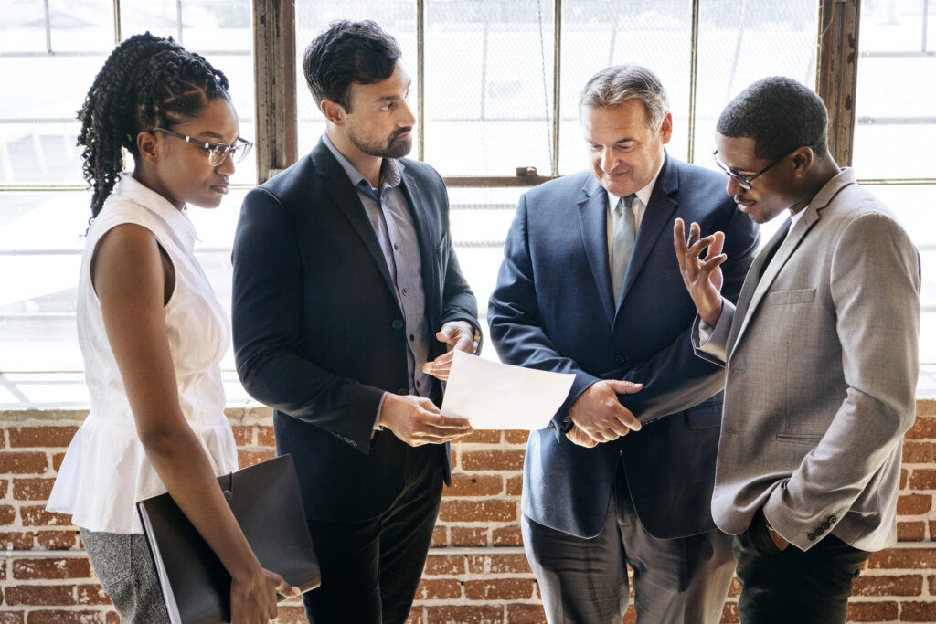 2020 search partners, A group a business professionals looking at a document